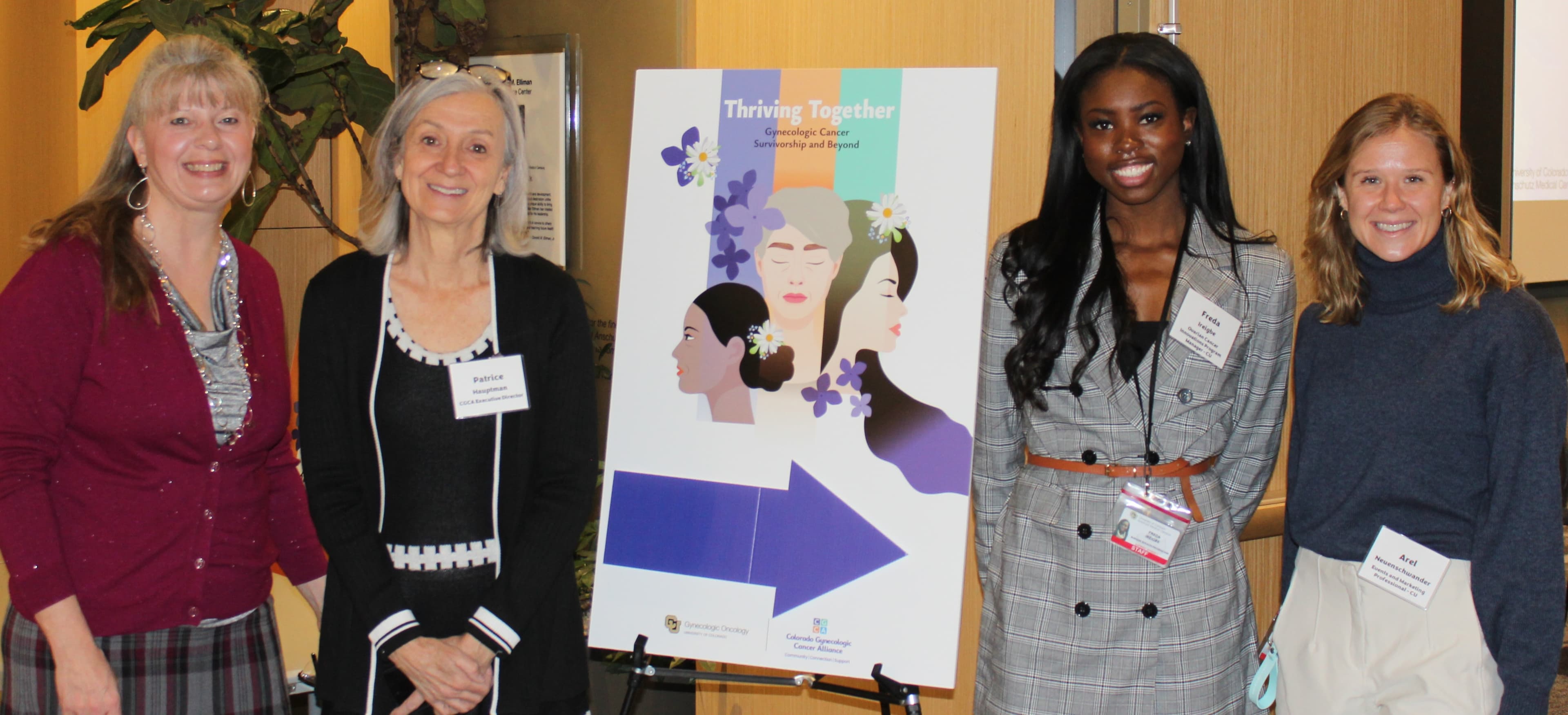 Patrice Hauptman, CGCA Executive Director, with three women beside a Thriving Together gynecologic cancer survivorship poster